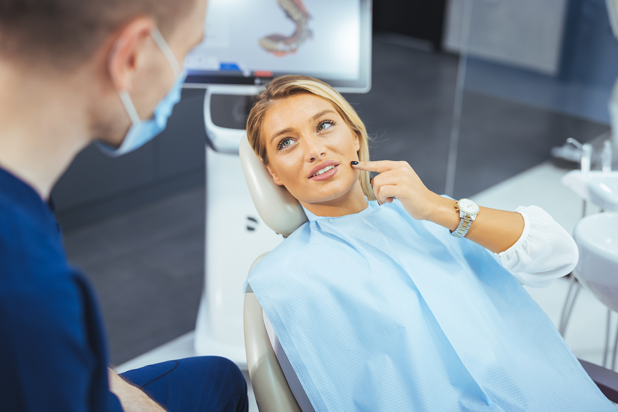 woman holding her jaw before wisdom tooth removal surgery at scholes family dental